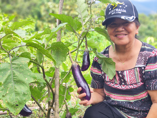 Farmer with her fruit bearing crops, grown using the skills she gain from our farming workshop.