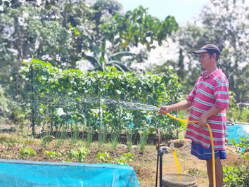 a farmer water his crops