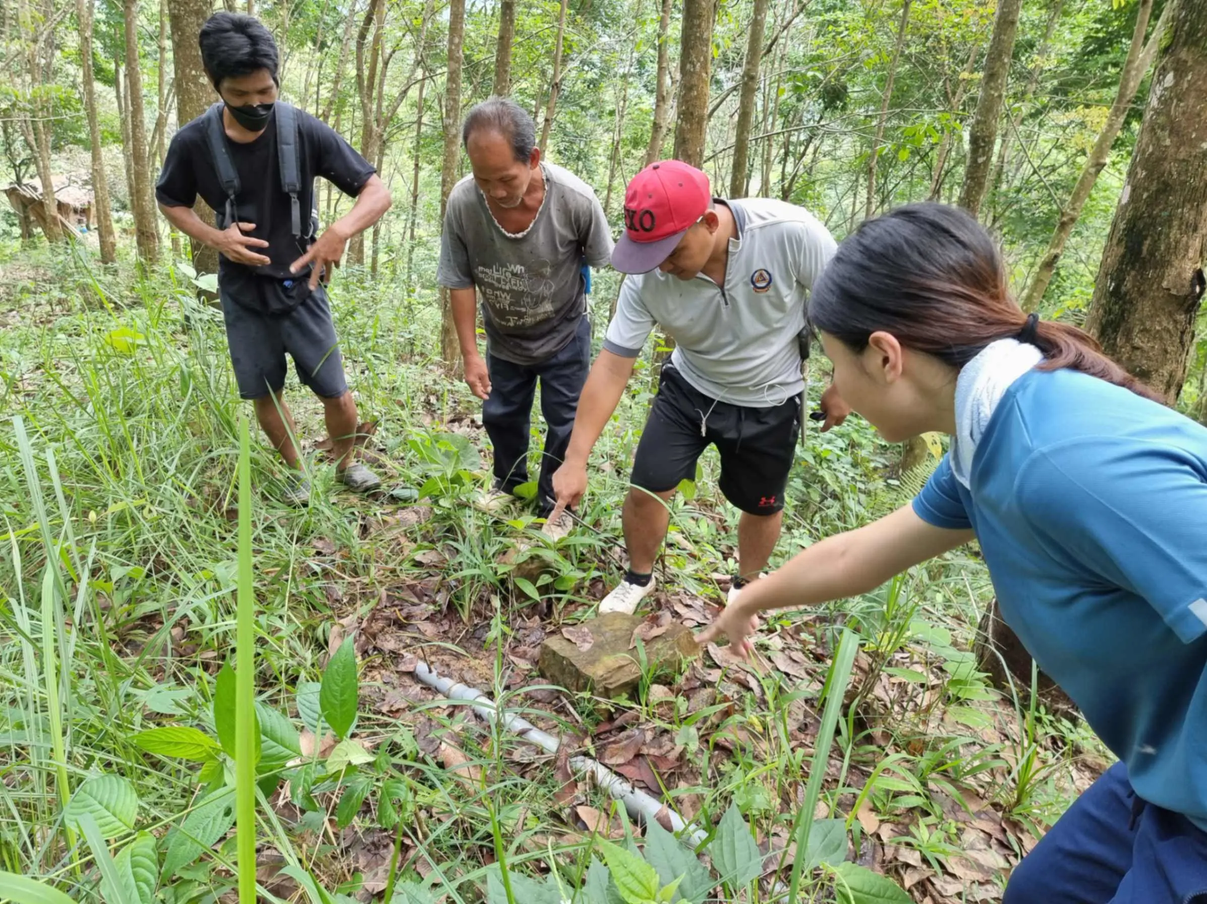 Villagers showing their old, broken pipes that have disrupted the community's water supply.