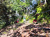Villagers working together to carry a water pipeline across rough terrain to the installation site.