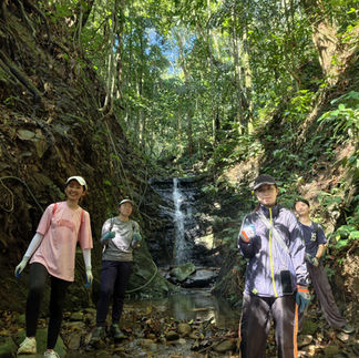 Volunteers taking a refreshing break by a waterfall along the Aura Montoria hike.