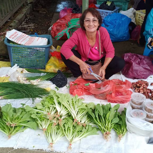 rural farmer selling a variety of her self grown vegetables at the market