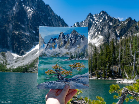 a photo of claire's painting from Colchuck lake, featuring the peaks and brilliant blue water
