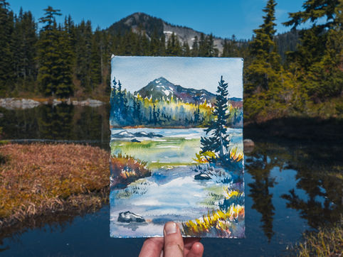 photo of claire's painting of a lake with trees and a mountain in the distance