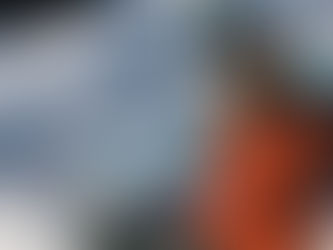 Claire works on a large painting in the snow wearing the proton