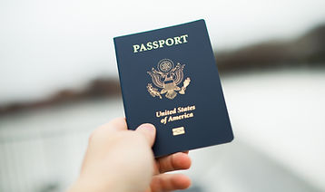 Close-up of a US passport with immigration, visa, citizenship, and travel paperwork on a w