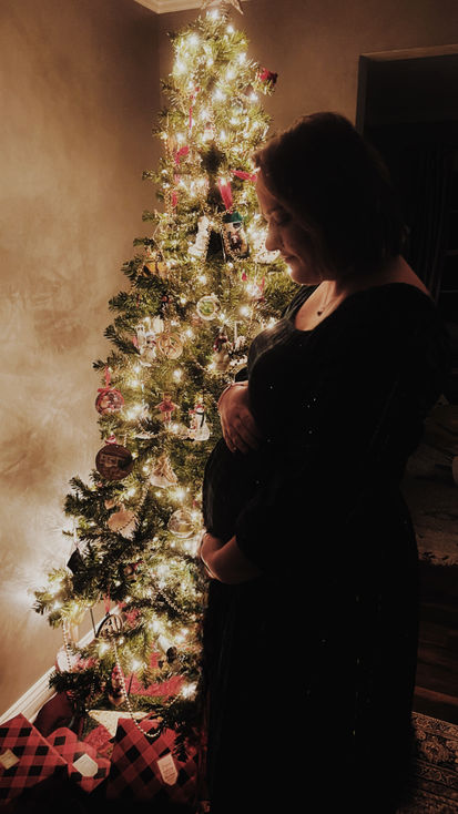 silhouette pregnant woman in front of christmas tree