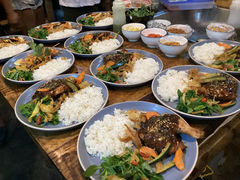A table in the kitchen with plated chicken dishes and other bowls of ingredients at DRYFT Camp