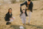 Parents with Child Running through Field