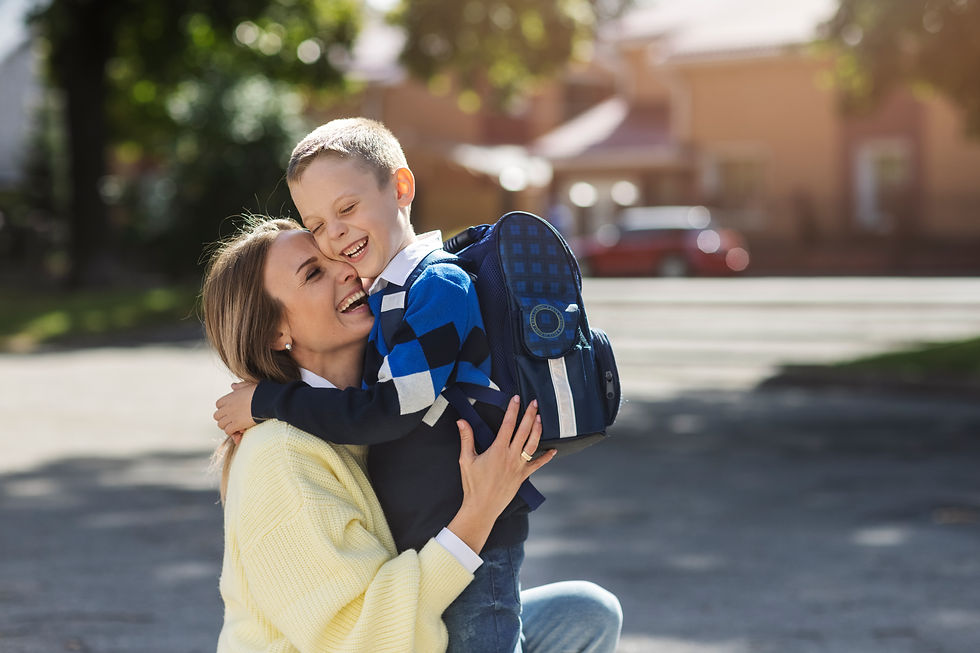 Mom with son at school dropoff, both are smiling and hugging