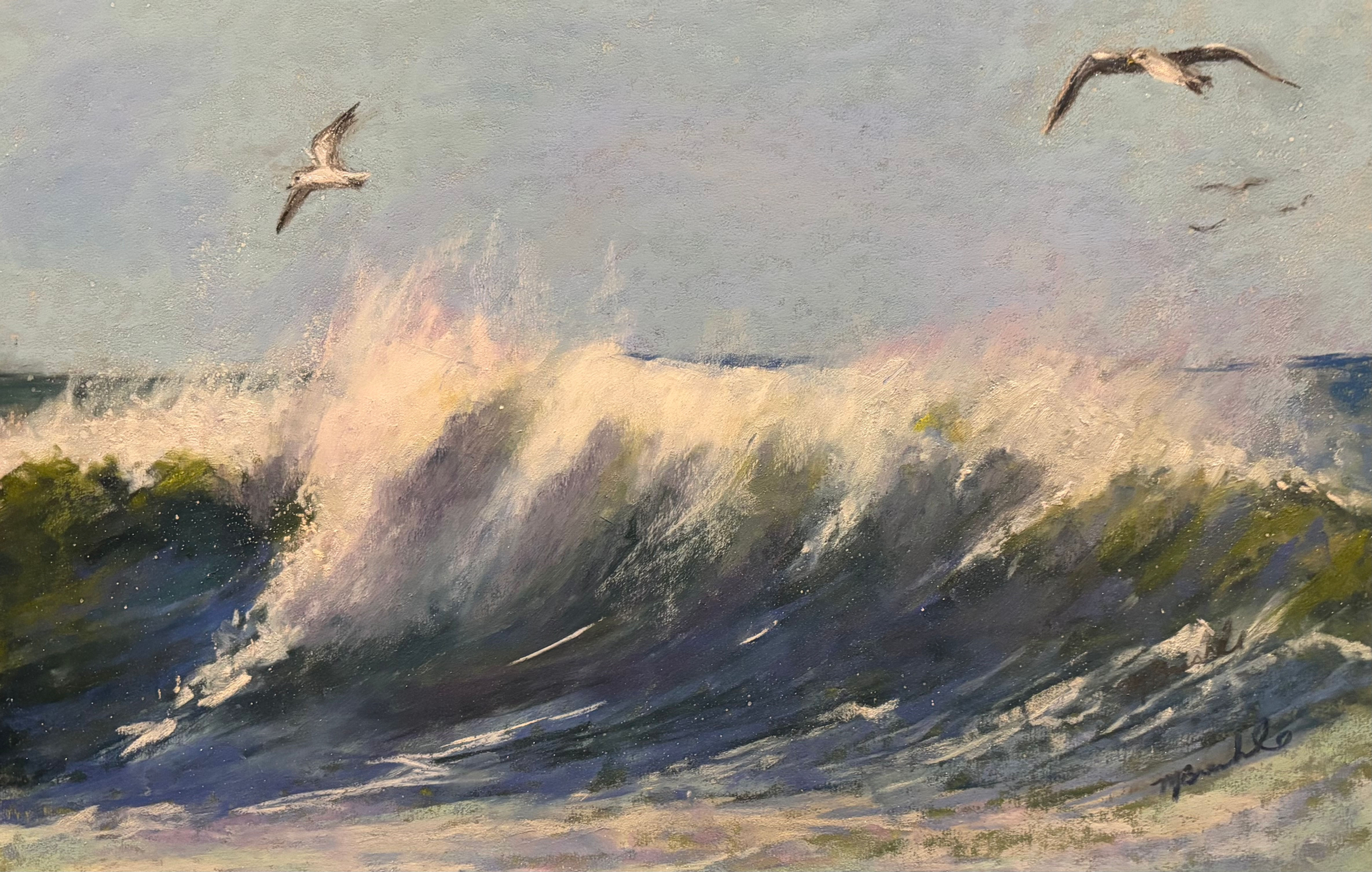 Sea birds flying above a cresting wave.