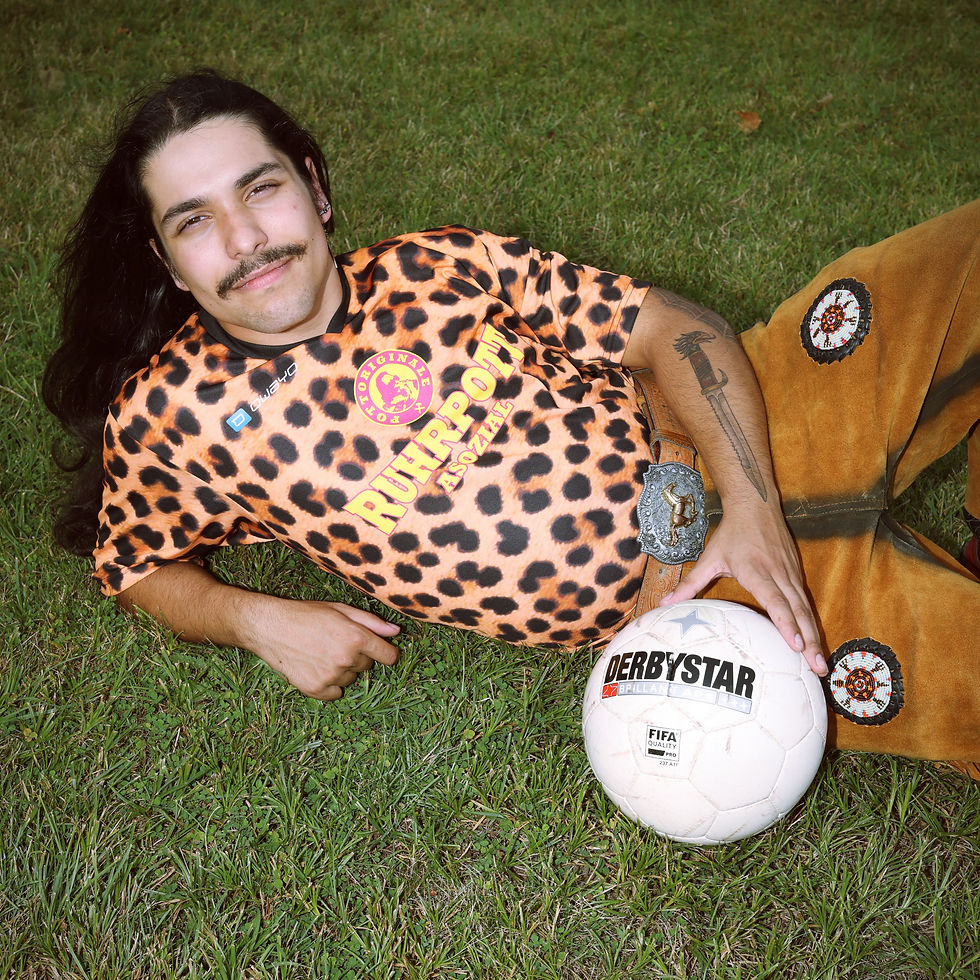 Miniaturbild: Ruhrpott Asi in einem Leoparden Design Trikot von Pottoriginale räkelt sich auf dem Rasen