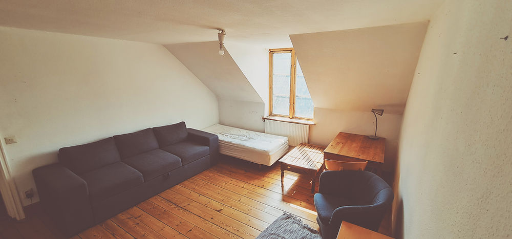 Student housing room in Lund with sofa, bed, and desk.