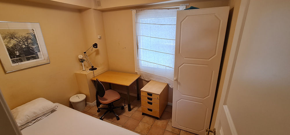 Cozy student housing room in Lund with bed, desk, and wardrobe.