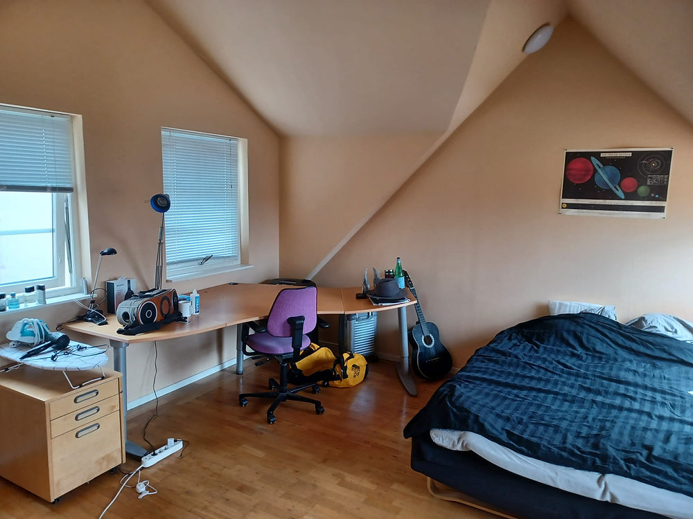 Lund student room with desk, bed, and guitar
