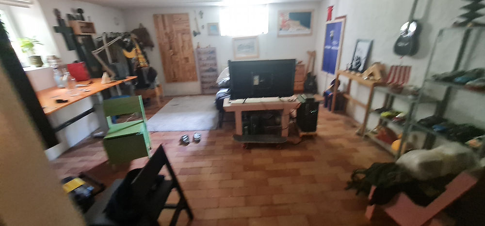 Common room in student housing with TV, sofa, and wooden floor