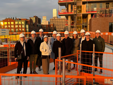 A group of business people in hard hats on a rooftop terrace