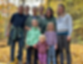Family posing amid fall foliage