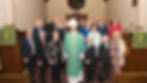 Bishop and congregation posing in front of altar