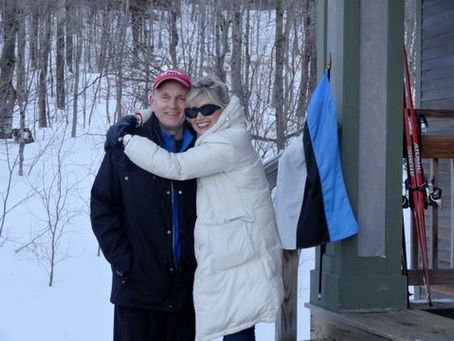 Couple posing outdoors in winter with Estonian flag
