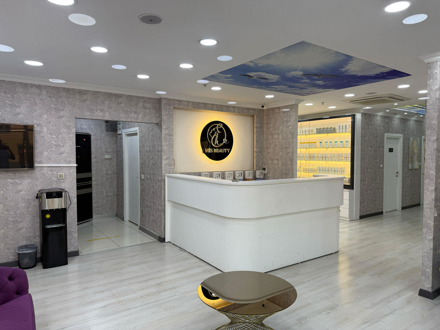 Beyaz resepsiyon ve salon girişi, tabelada logo, His Beauty Yorumları, aydınlık iç mekan tasarımı.