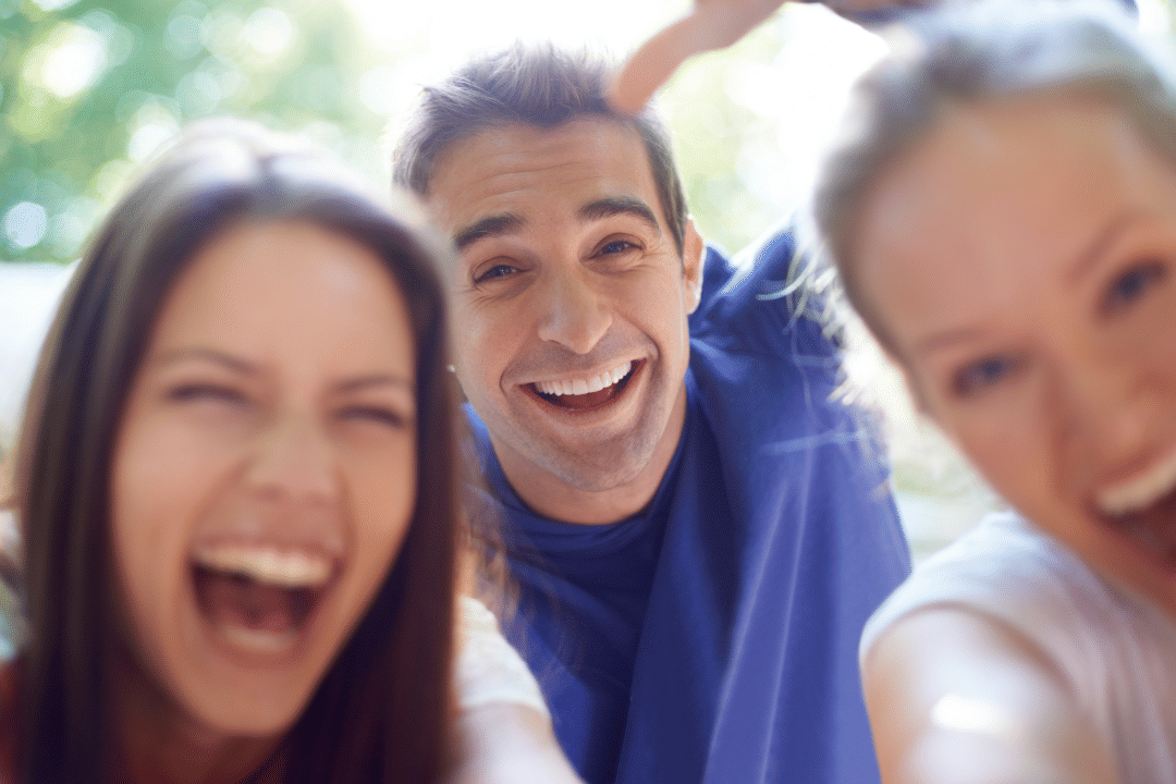 Gülümseyen üç genç insan, poz veriyor. Mutluluk ve eğlence dolu anlar.