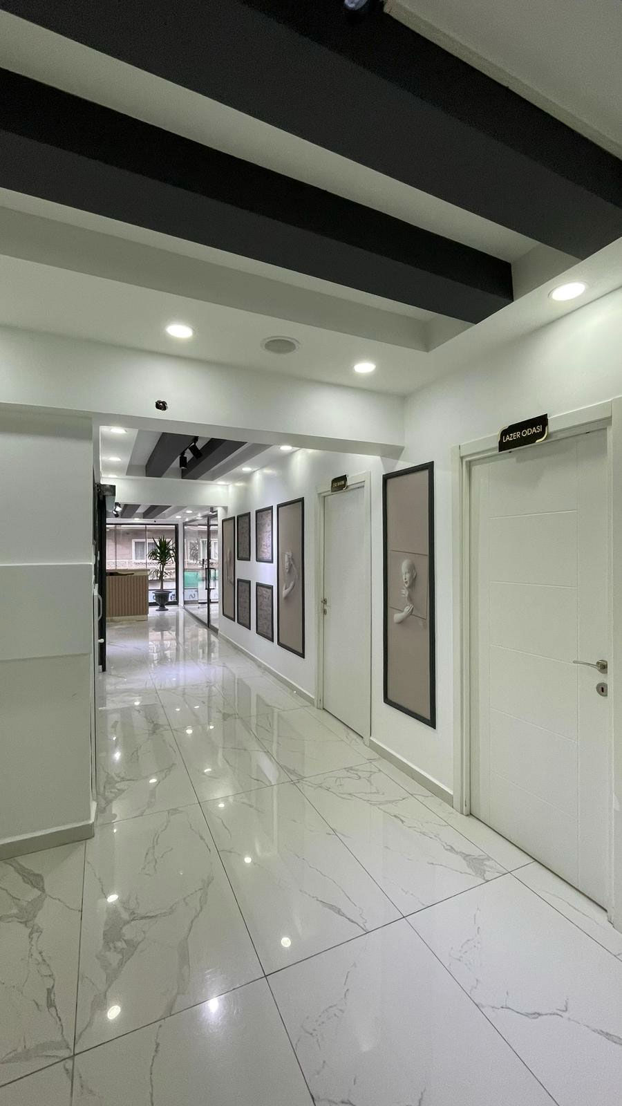 Diş klinik koridorunda kapılar ve aynalar, Aksa Diş Yorumları, aydınlık ve temiz.