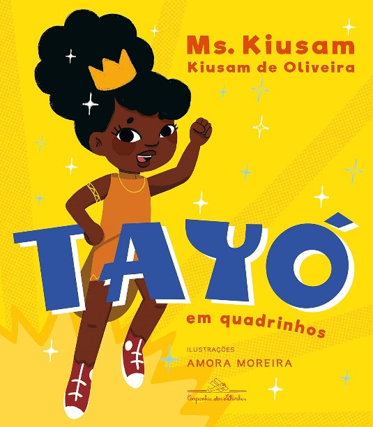 Capa do livro. Num fundo amarelo, A personagem Tayó usa uma coroa dourada e com o punho fechado, sorri.