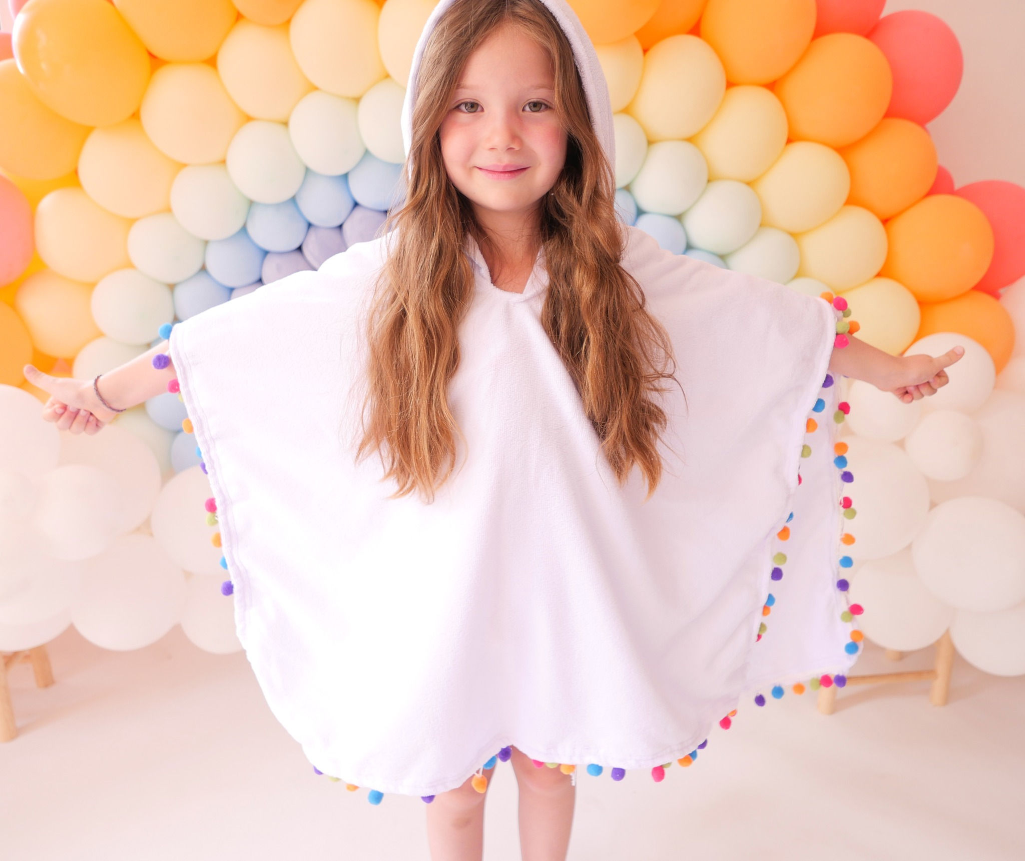 Poncho con pompones de colores