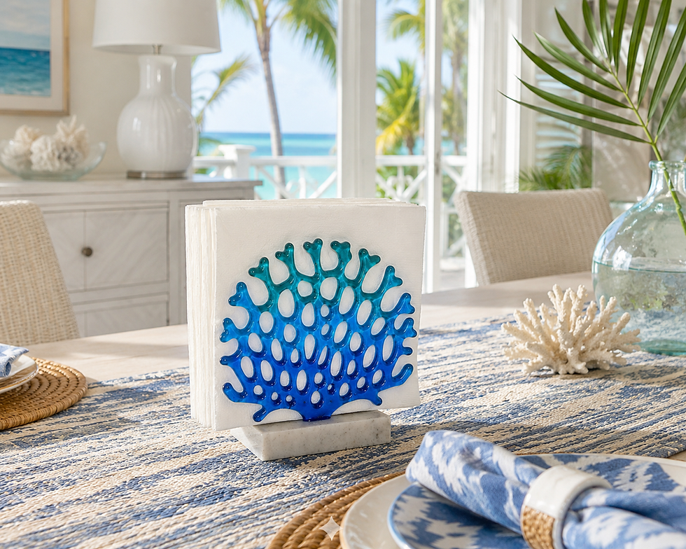 Glass coral napkin holder styled on a coastal dining table in a bright beach-inspired home