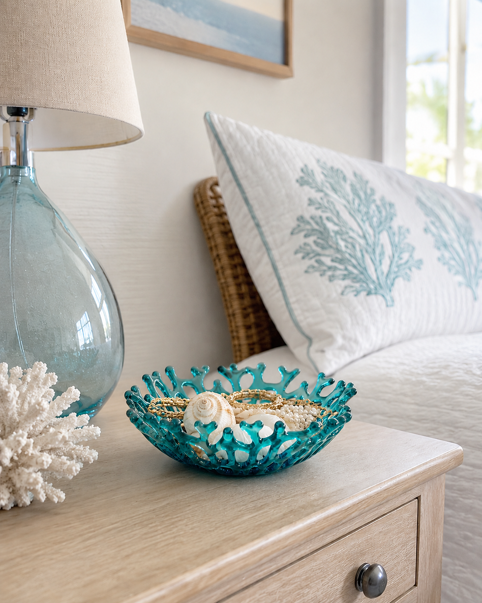 Small glass coral bowl styled on a nightstand in a bright coastal bedroom