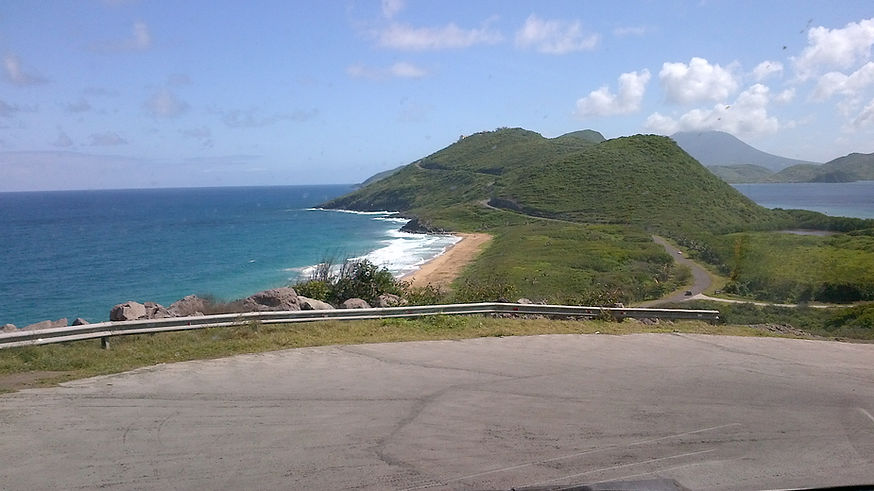 Panoramic view of St. Kitts mountains, coastline, and road representing the range of guests we host