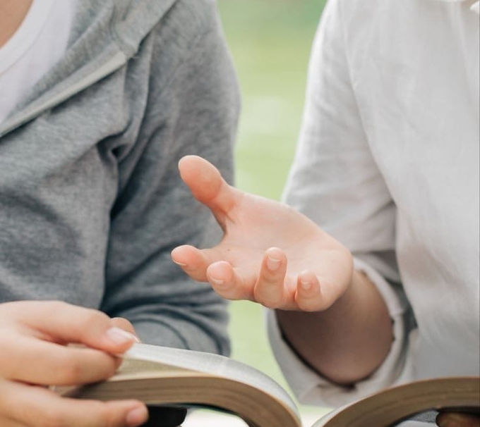 A picture of two people reading the Bible representing Evangelism.