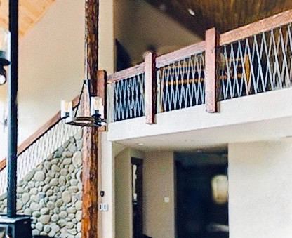 Intricate custom metalwork installed inside rustic wood rail, blending natural materials with precision detailing by NW Metalworks.