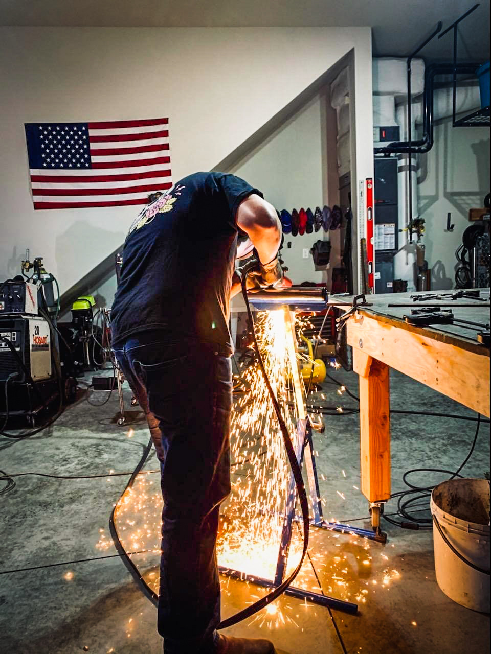 Casey using a handheld plasma torch to cut metal with precision, captured during fabrication work in Vancouver, WA
