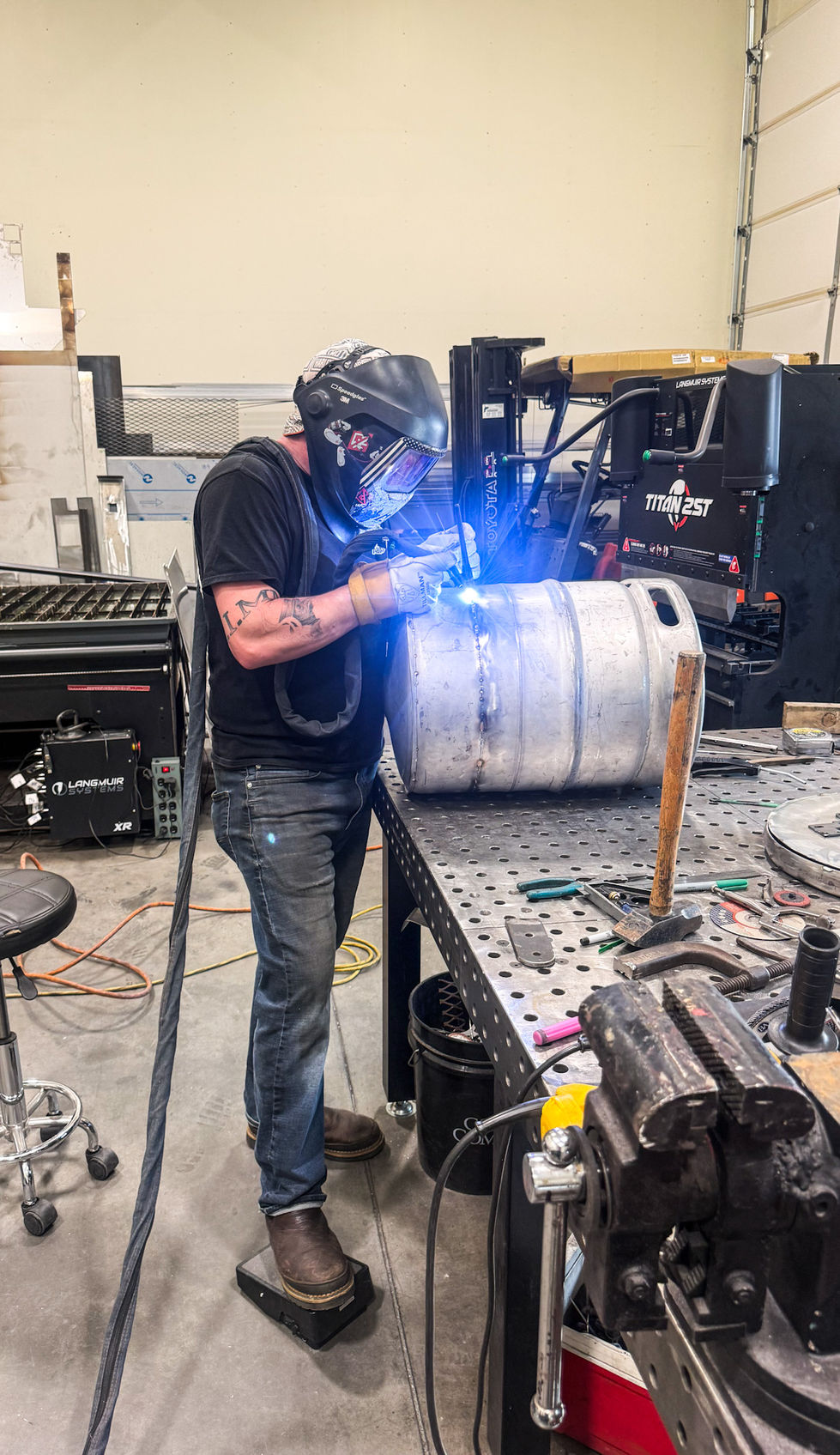 Welder welding custom stainless steel crab cooking pot during fabrication at NW Metalworks