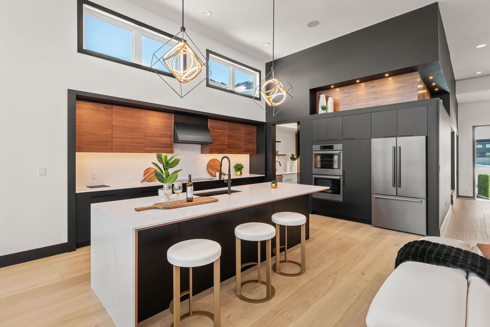 Kitchen at 6 Avonlynn Court with large island, black cabinetry, wood accents, pendant lighting, and stainless steel appliances.