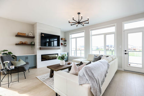 Living room at 3 Benjamin Boulevard with fireplace feature wall, mounted TV, large windows, and bright seating area.