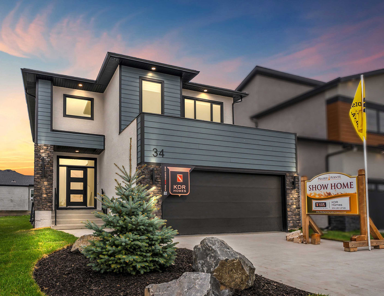 Front exterior of 34 Firestone Drive showing a modern show home design with attached garage and landscaped entry.