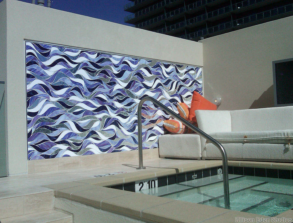 This exquisite custom stained glass mosaic, meticulously handcrafted by Allison Eden, brings a dynamic wave pattern to life, transforming this outdoor desert spa into a tranquil oasis. Designed exclusively for the Cosmopolitan Casino in Las Vegas, the flowing composition of iridescent blues, deep purples, and shimmering mirrored tiles creates a mesmerizing interplay of light and movement. The undulating design echoes the fluidity of water, offering a striking yet serene focal point that perfectly complements the luxurious ambiance of this rooftop retreat.