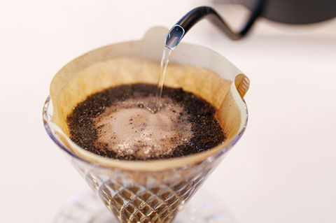 ドリップフィルターのコーヒー粉に細く湯が注がれる瞬間。