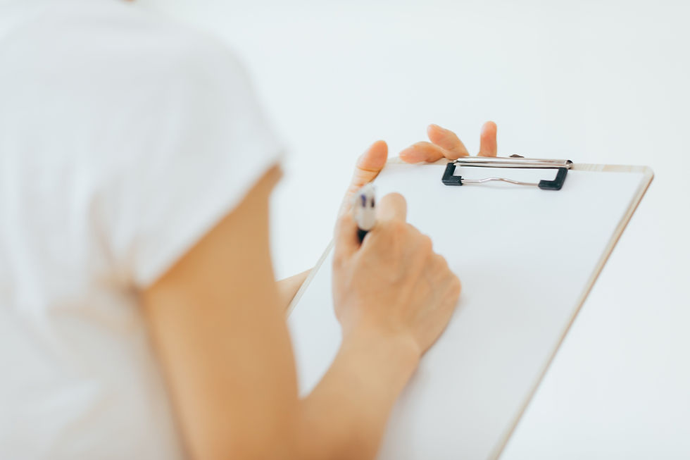 白いシャツを着た女性が、クリップボードにペンで書いています。背景は白。