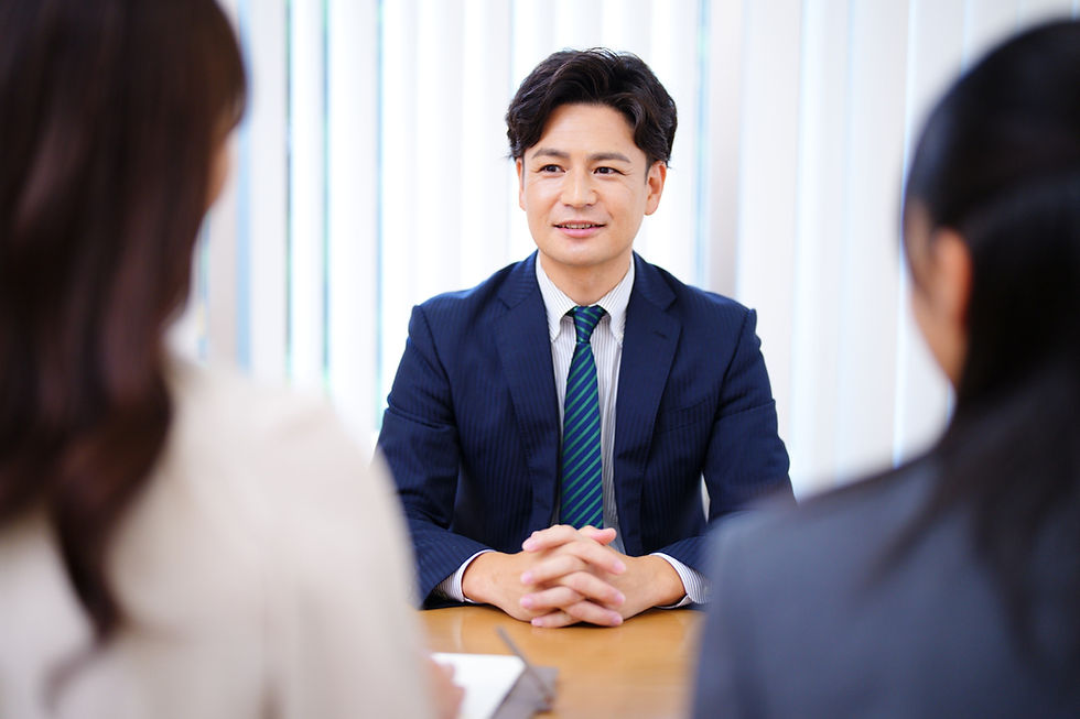 面接中の男性、二人の女性面接官と笑顔で話す様子。ビジネスシーン。