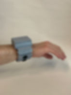 Picture featuring a man wearing the HapWare wristband. This new design has grey plastic links that house the haptic motors. It is ergonomic, sleek, and designed to support real-time communication.
