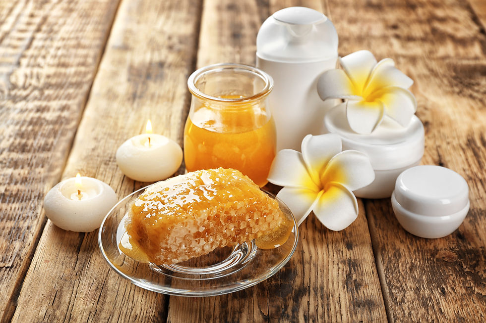Honey comb on a plate with a honey jar and jars of honeybee related products