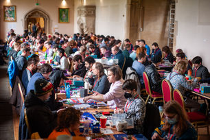 A wide shot of the Arts Mansion at Ashton Court. There are rows long rows of people playing the card game netrunner on long tables