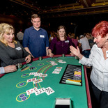 Blackjack Dealer with players at a casino night party