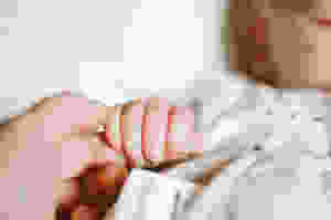 Baby's hand holding mother's finger
