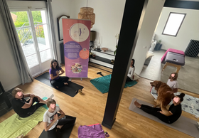 Participants allongés au sol pendant un atelier de relaxation mères-filles guidé par Yasmina Radulovic