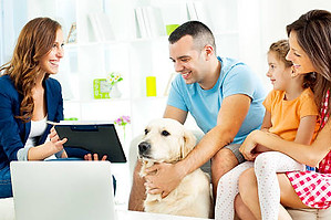 Couple with child and dog looking at some information with a female